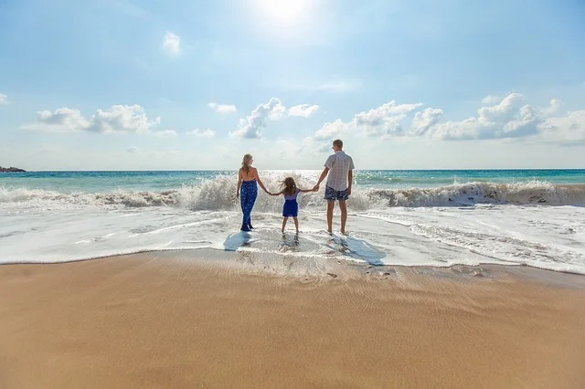 Familia feliz de Vacaciones en una paradisíaca playa, disfrutando de unas vacaciones con niños